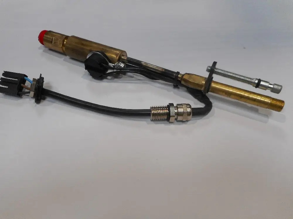 Düsenstock von Remeha mit zwei Metallrohren, Kabelanschluss und einer roten Kappe. Klare Sicht auf die Verbindungsteile und den Anschluss für die Elektronik.